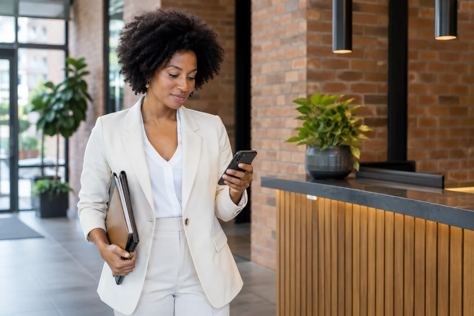 Woman using her phone in an office lobby.