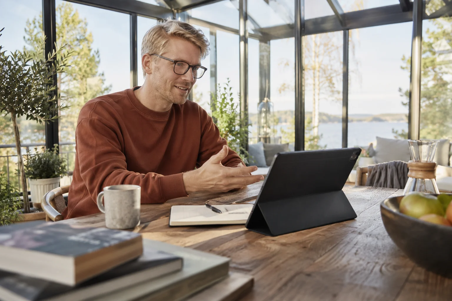 Professional working at a tablet in a glass conservatory.