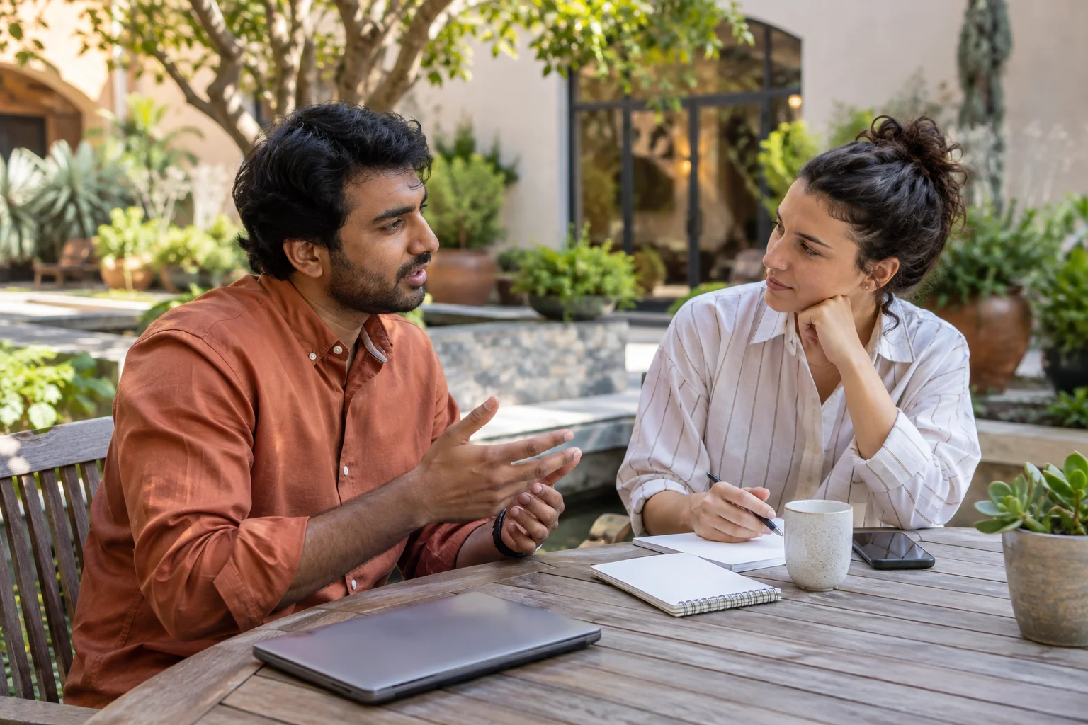 Colleagues discussing a meeting plan in a courtyard.